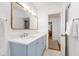 Updated bathroom with blue vanity, quartz countertop, gold hardware, and large mirror at 3028 Rothgeb Dr, Raleigh, NC 27609