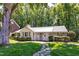 Charming white brick home with manicured landscaping, stone walkway, and a metal roof at 3028 Rothgeb Dr, Raleigh, NC 27609