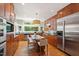 Gourmet kitchen with wood cabinets, stainless steel appliances, and eat-in island at 3028 Rothgeb Dr, Raleigh, NC 27609