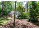 Expansive backyard showcasing lush greenery, a charming wooden swing, and a dedicated play area at 305 Monterey Ct, Benson, NC 27504
