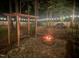 Backyard featuring fire pit, swing and playhouse illuminated at night by string lights at 305 Monterey Ct, Benson, NC 27504