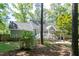 Backyard view featuring swing, stone patio, and play area with lush greenery at 305 Monterey Ct, Benson, NC 27504