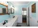 Bright bathroom with double vanity, framed mirrors, and a view into the bedroom at 305 Monterey Ct, Benson, NC 27504