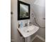 Clean bathroom with a pedestal sink, vanity mirror, and bright lighting at 305 Monterey Ct, Benson, NC 27504