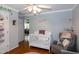The Bedroom includes a white crib, rocker, and hardwood floors; living room visible in background at 305 Monterey Ct, Benson, NC 27504