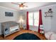 Bedroom features a crib, baseball decor, wood floors, ceiling fan and natural light at 305 Monterey Ct, Benson, NC 27504