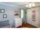 This Bedroom features a white dresser with changing table, wooden floors, and light blue walls at 305 Monterey Ct, Benson, NC 27504