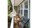 Inviting front porch featuring chairs, a view to the lush lawn, and natural light filtering through the trees at 305 Monterey Ct, Benson, NC 27504