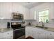 Modern kitchen with stainless appliances and white cabinets at 305 Monterey Ct, Benson, NC 27504