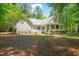 A spacious backyard with a manicured lawn, mature trees, and charming home exterior at 3201 Keighley Forest Dr, Wake Forest, NC 27587