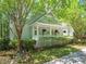 Charming home exterior with a welcoming front porch, lush landscaping, and a well-manicured lawn at 3201 Keighley Forest Dr, Wake Forest, NC 27587