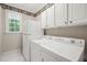 Laundry room features white appliances, storage cabinets and a charming lighthouse-themed wallpaper border at 3201 Keighley Forest Dr, Wake Forest, NC 27587