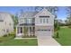 Charming two-story home featuring stone accents, a gray color palette and a manicured front lawn at 3217 Armeria Dr, Apex, NC 27502