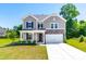 Beautiful two-story home boasting stone accents, a two-car garage, and well-maintained landscaping at 325 Porterfield Dr, Youngsville, NC 27596