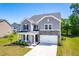 Lovely two-story home with a well-manicured lawn and a two-car garage at 325 Porterfield Dr, Youngsville, NC 27596
