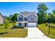Charming two-story home with gray siding, stone accents, well-maintained lawn, and an inviting front porch at 325 Porterfield Dr, Youngsville, NC 27596