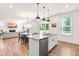 Bright kitchen with white cabinets, granite countertops, stainless steel appliances, and an open view to the living room at 325 Porterfield Dr, Youngsville, NC 27596