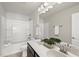 Well-lit bathroom showcasing dual sinks, a dark vanity, and a shower-tub combination at 3406 Antler View Dr, Apex, NC 27502