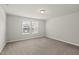 A spacious bedroom with neutral walls, plush carpet, and two windows at 3406 Antler View Dr, Apex, NC 27502