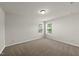 A spacious bedroom with neutral walls, plush carpet, and two windows at 3406 Antler View Dr, Apex, NC 27502