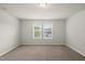 A spacious bedroom with neutral walls, plush carpet, and two windows at 3406 Antler View Dr, Apex, NC 27502