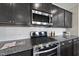 Modern kitchen with stainless steel appliances, dark cabinets, granite countertops, and a subway tile backsplash at 3406 Antler View Dr, Apex, NC 27502