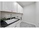 Functional laundry room with ample cabinet storage, a sink, and neutral flooring at 3406 Antler View Dr, Apex, NC 27502