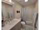 Modern bathroom with a neutral vanity, mirror and shower over bath and tiled floor at 3523 Ivy Commons Dr # 102, Raleigh, NC 27606