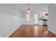 Bright dining area featuring hardwood floors and a charming light fixture adjacent to the kitchen at 3603 Westmeadow Ln, Elon, NC 27244