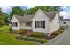 Well-maintained exterior view showcasing a white home with black shutters and a spacious gravel driveway at 3603 Westmeadow Ln, Elon, NC 27244