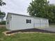 White metal building features two large garage doors, side entry, and dark shutters at 3603 Westmeadow Ln, Elon, NC 27244