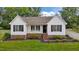 Charming home with fresh white siding, black shutters, brick accents, and meticulously maintained front yard at 3603 Westmeadow Ln, Elon, NC 27244