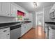 Traditional kitchen featuring white cabinets, dark countertops, stainless steel appliances, and hardwood floors at 3603 Westmeadow Ln, Elon, NC 27244
