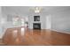 Open living room with hardwood floors, a fireplace, and seamless access to the kitchen and dining area at 3603 Westmeadow Ln, Elon, NC 27244