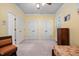 Yellow bedroom featuring 2 closets, ceiling fan, and two chairs, designed for convenience and relaxation at 39 Forked Pine Ct, Chapel Hill, NC 27517
