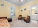 Carpeted bedroom with ceiling fan, two chairs and bathroom access, designed for relaxation and convenience at 39 Forked Pine Ct, Chapel Hill, NC 27517