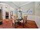 Elegant dining room with a modern chandelier, hardwood floors, and wainscoting at 39 Forked Pine Ct, Chapel Hill, NC 27517
