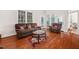 Comfortable living room with hardwood floors, a brown couch, and access to the backyard at 39 Forked Pine Ct, Chapel Hill, NC 27517