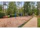 Community playground with swings, climbing structure, and a walking path, set among shade trees at 39 Forked Pine Ct, Chapel Hill, NC 27517