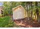 Storage shed surrounded by grass and mulch, nestled among mature trees offering backyard storage at 39 Forked Pine Ct, Chapel Hill, NC 27517