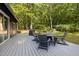 Relaxing back deck features a dining set, grill, and a view of the serene wooded landscape at 4022 Tecolote Way, Hillsborough, NC 27278