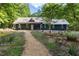 Charming home exterior with metal roof, landscaped yard, and inviting front porch with rocking chairs at 4022 Tecolote Way, Hillsborough, NC 27278