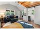 Cozy living room with wood floors, vaulted ceilings, stylish rug, and a glimpse into the updated bathroom at 4022 Tecolote Way, Hillsborough, NC 27278