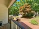 Spacious backyard with a shed, partially fenced in and a patio deck with an orange-leafed tree nearby at 4057 Old Franklinton Rd, Franklinton, NC 27525