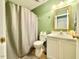 Cozy bathroom with a shower/tub combo, white vanity, neutral tile flooring and green walls at 4057 Old Franklinton Rd, Franklinton, NC 27525