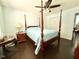 Comfortable bedroom featuring a four-poster bed, hardwood floors, and ample natural light at 4057 Old Franklinton Rd, Franklinton, NC 27525