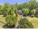 Aerial view of a brick home with extensive lawn, mature trees, and private driveway at 412 Bowen Rd, Rougemont, NC 27572