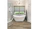 Modern bathroom featuring a standalone tub, glass shower, and stylish light fixture, creating a spa-like retreat at 412 Bowen Rd, Rougemont, NC 27572