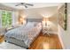 A well lit bedroom with hardwood floors, a patterned bedspread, and two end tables with lamps at 412 Bowen Rd, Rougemont, NC 27572