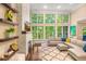 Bright living room with floor-to-ceiling windows, stone fireplace, and comfortable seating, perfect for relaxation at 412 Bowen Rd, Rougemont, NC 27572